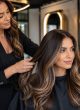 Balayage and Keratin Hair Treatments in Wembley Hairstylist working with long glossy balayage hair in a modern Wembley salon